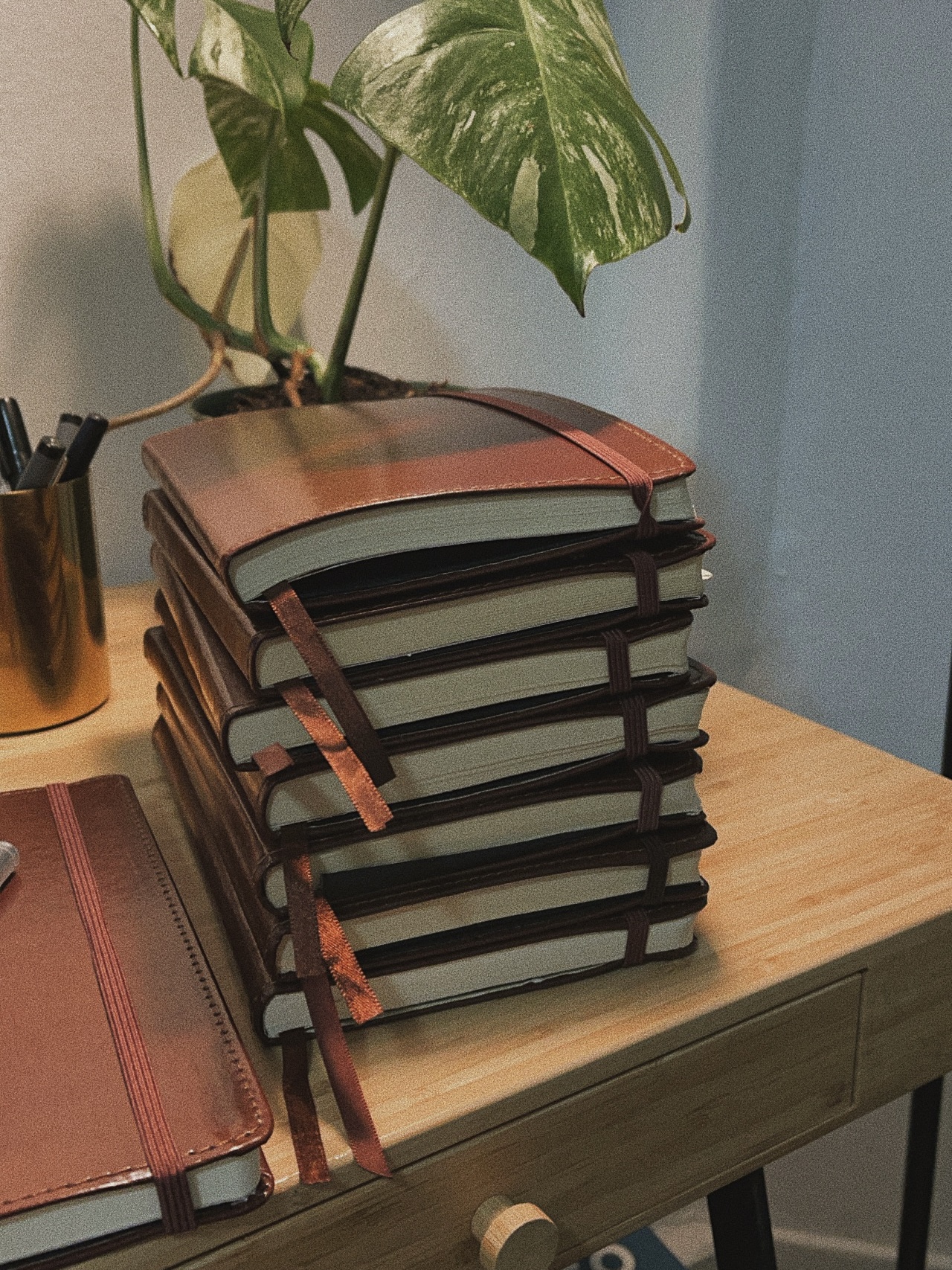 Stack of handwritten journals on a desk
